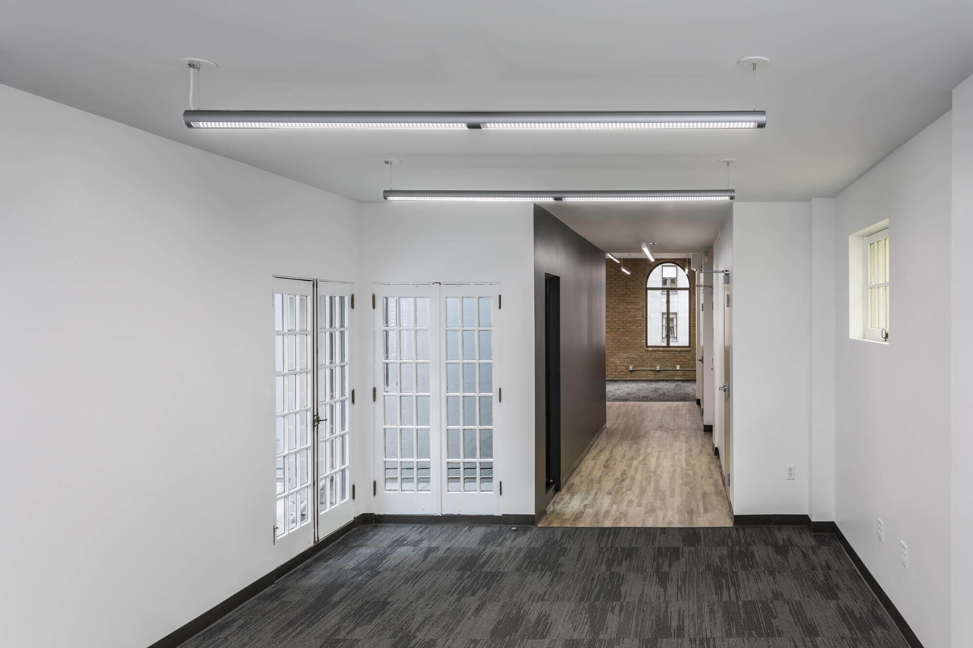 The Athletics san francisco office having a room with a wooden floor, white painted walls and large glass window