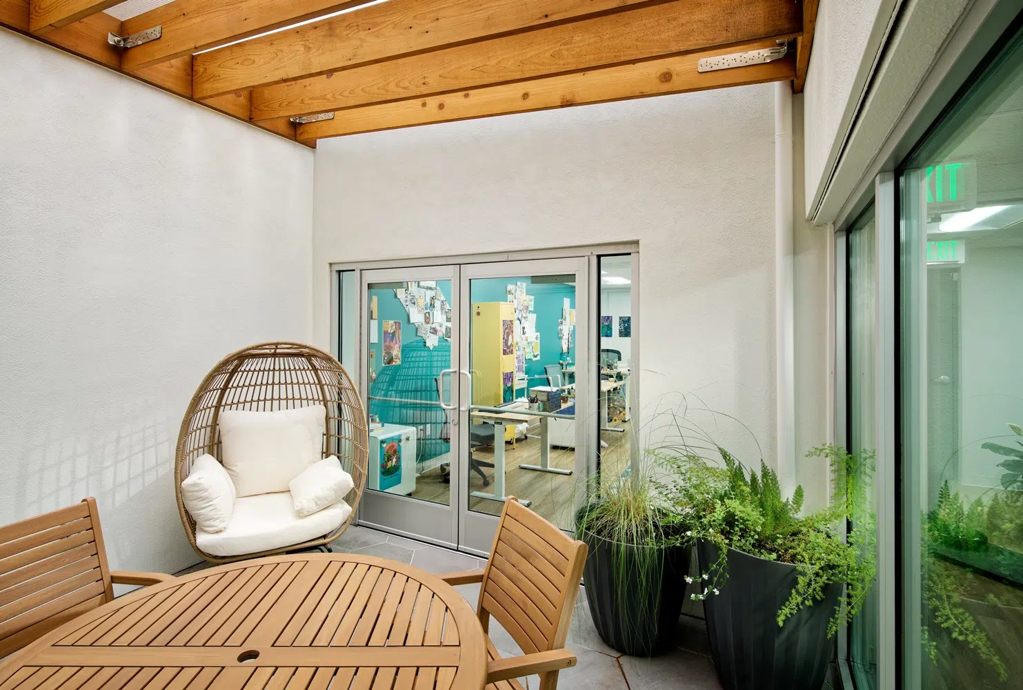 break room in an office including white seating, wooden furniture and plants