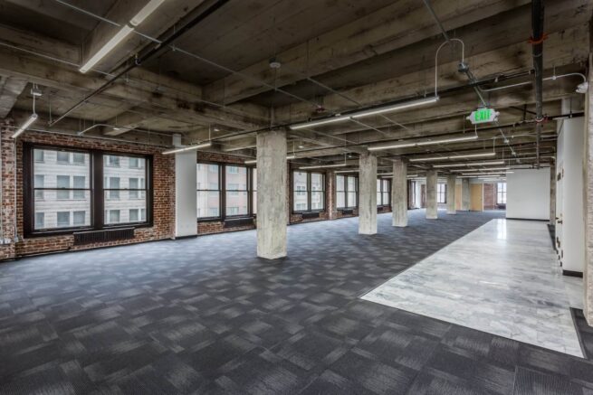office space with black flooring and pillars