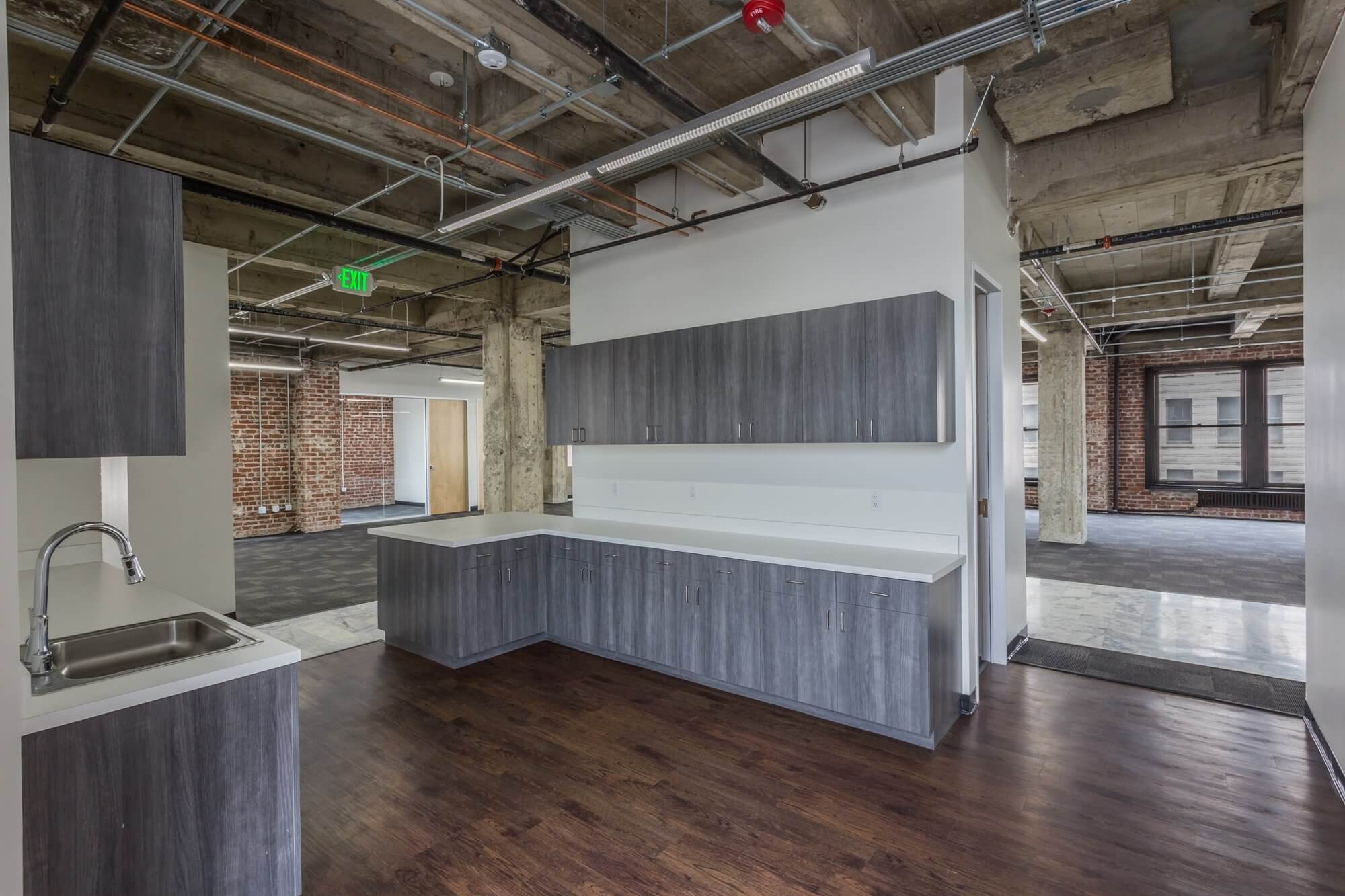 office space with black flooring, pillars and white walls