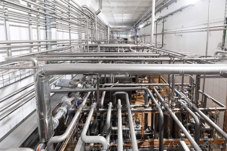 Metallic pipes isolated on factory background.