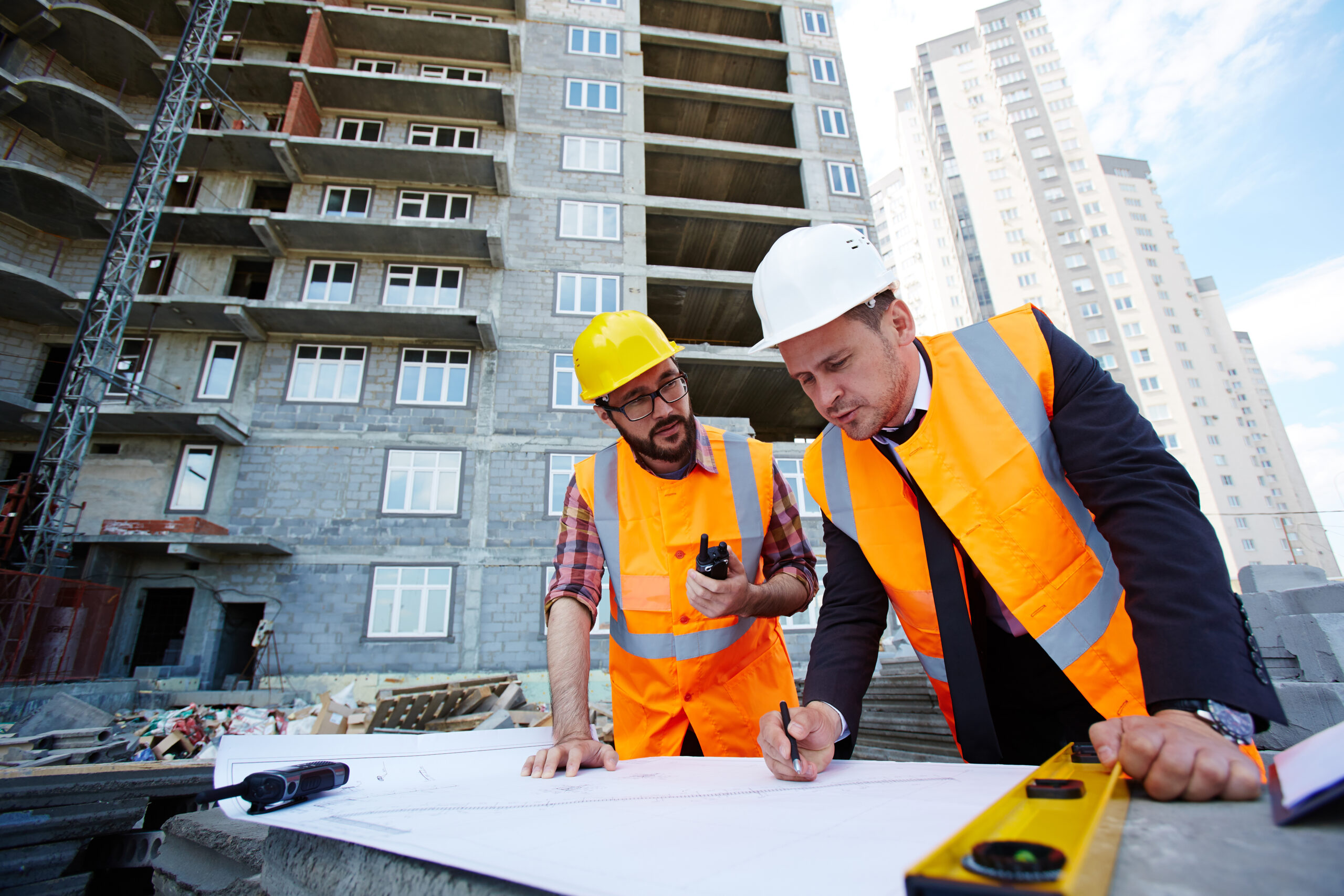 Commercial engineers pointing at sketch in blueprint