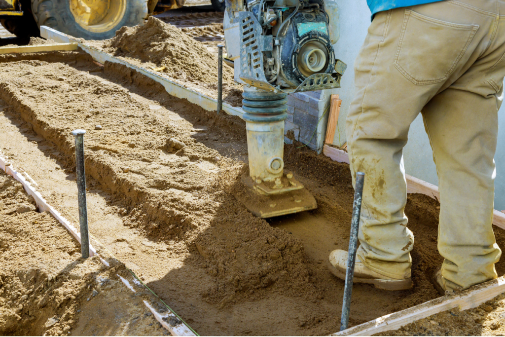 Construction Worker Using Tamping Rammer in Compacting Ground
