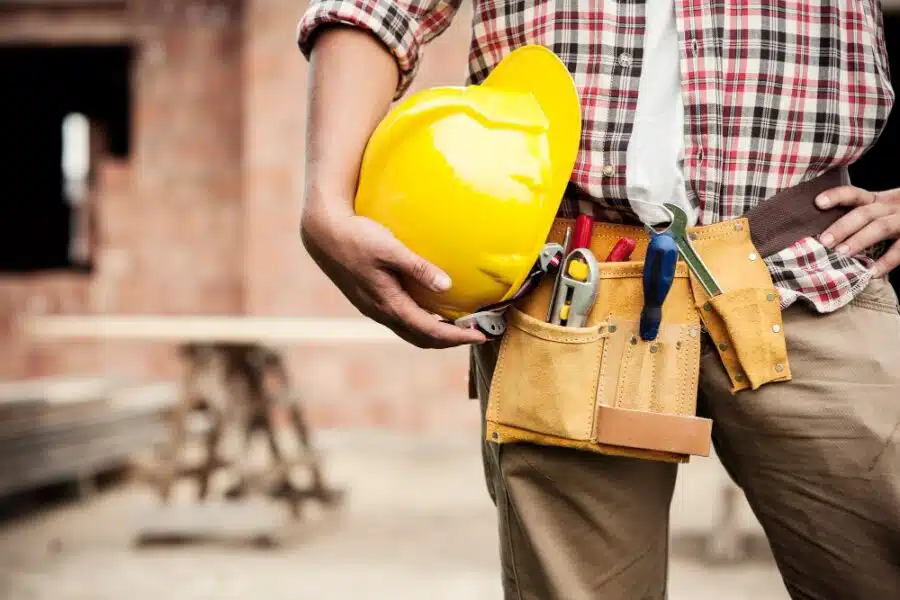 a construction worker holding hard hat and other materials