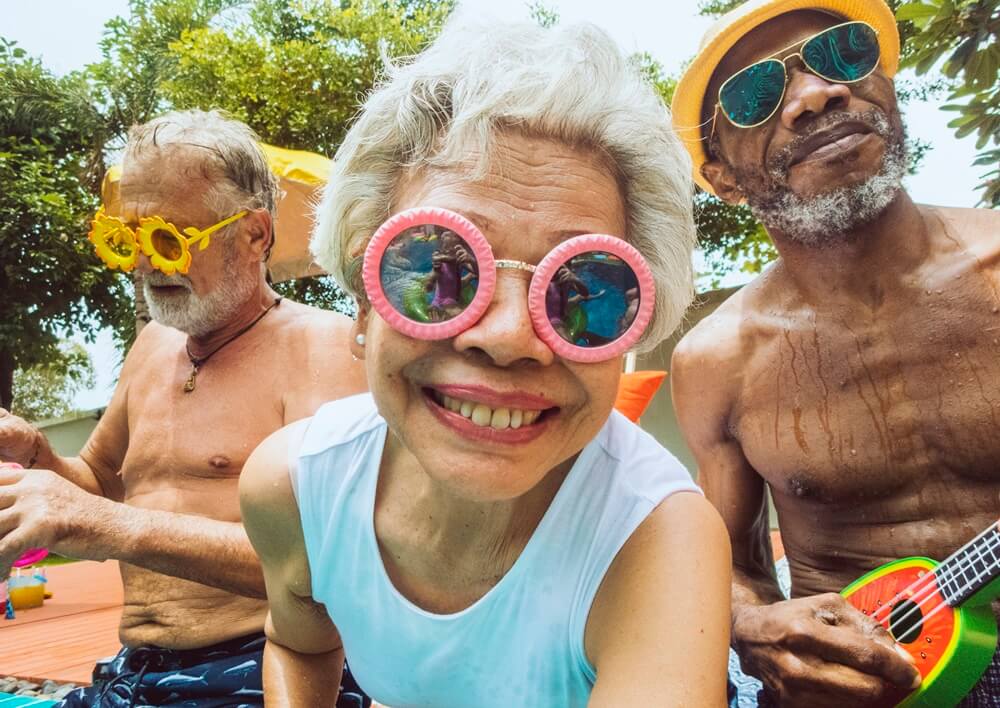 diverse senior adults sitting by the pool enjoying summer together