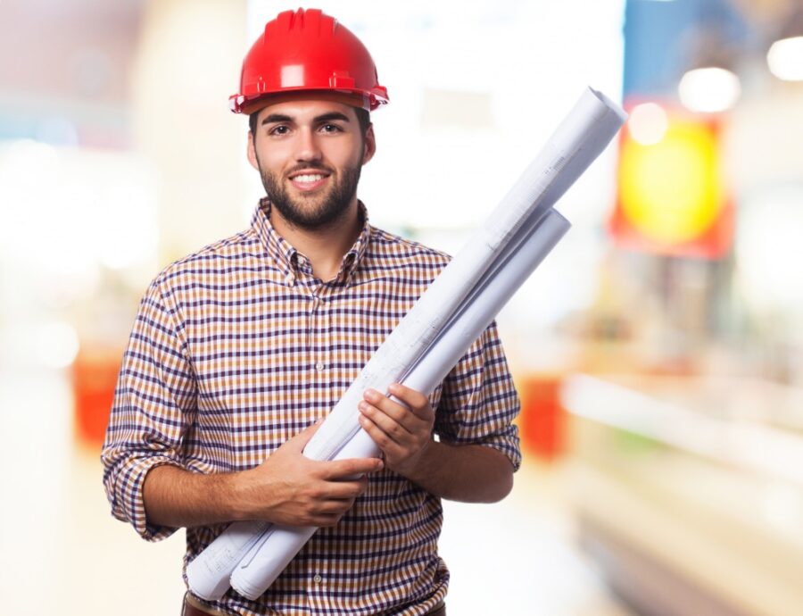 commercial general contractor wearing red helmet and carrying blueprint