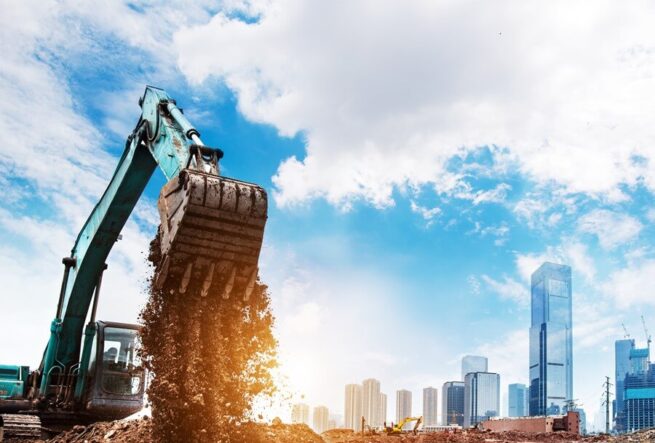 excavator digging soil in front of building