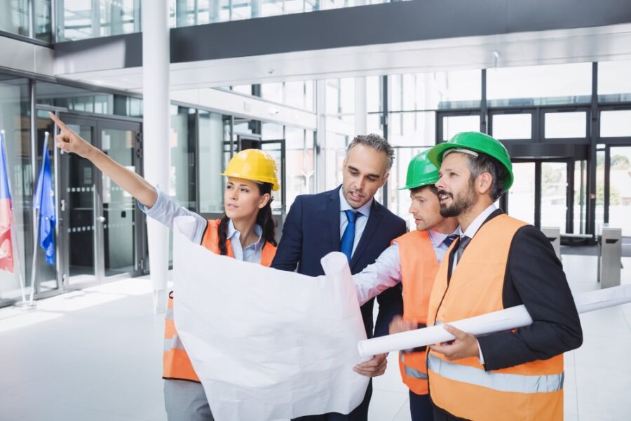 construction team with blueprint discussing on site