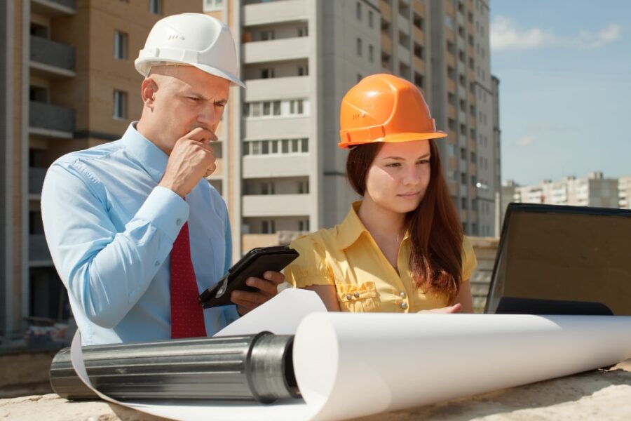 two construction team members looking at a laptop on construction site