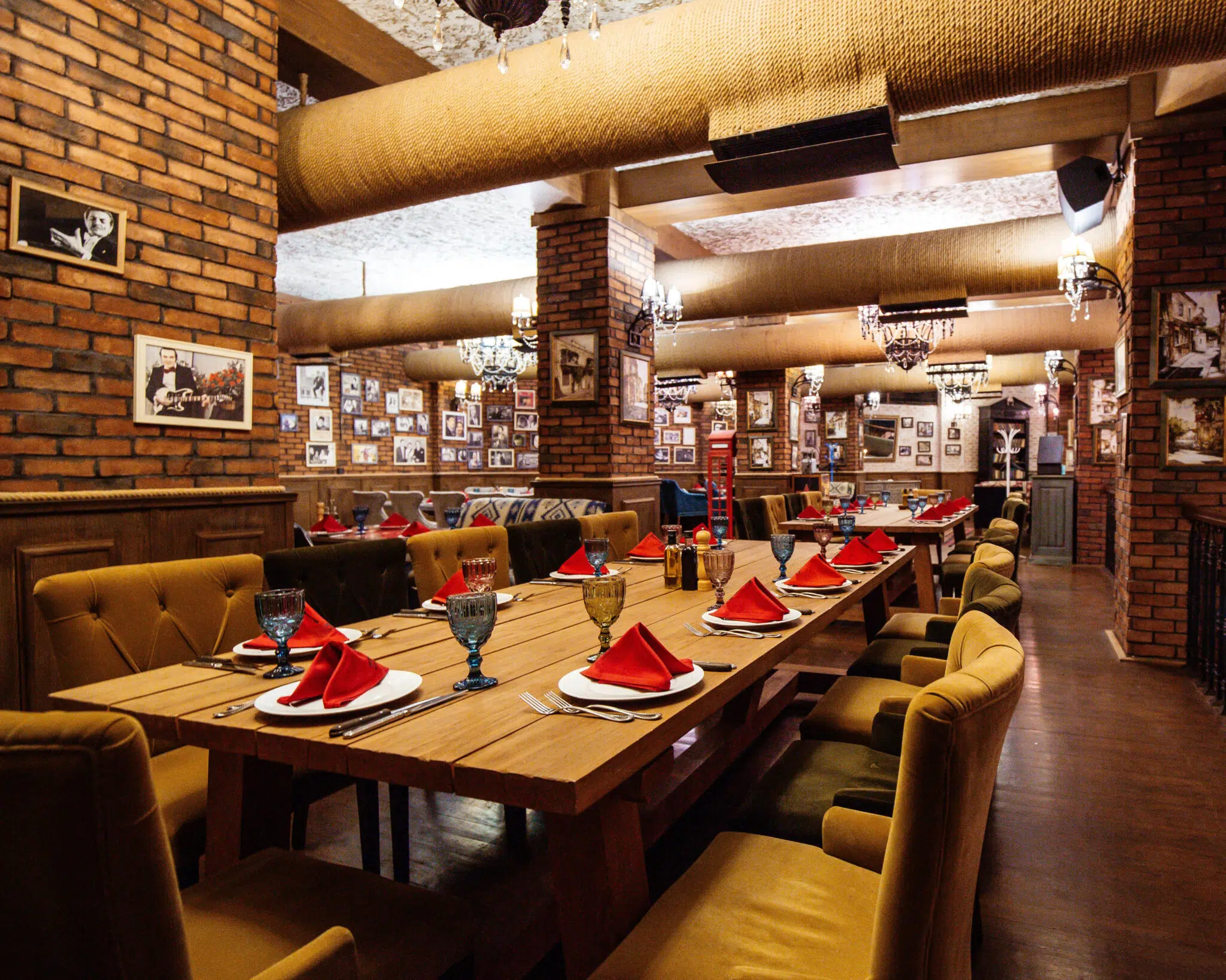 Restaurant Construction A restaurant hall with construction of red brick walls wooden tables and pipes in the ceiling
